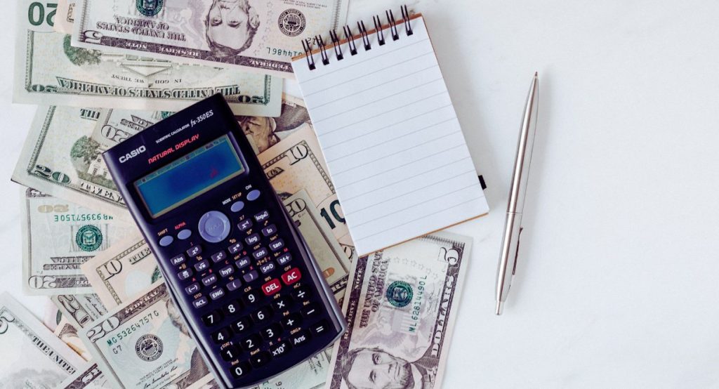 Calculatrice posee sur des billets pour estimer le budget du permis