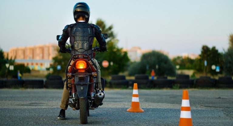 Motard en tenue de protection sur une piste d'entrainement avec plots