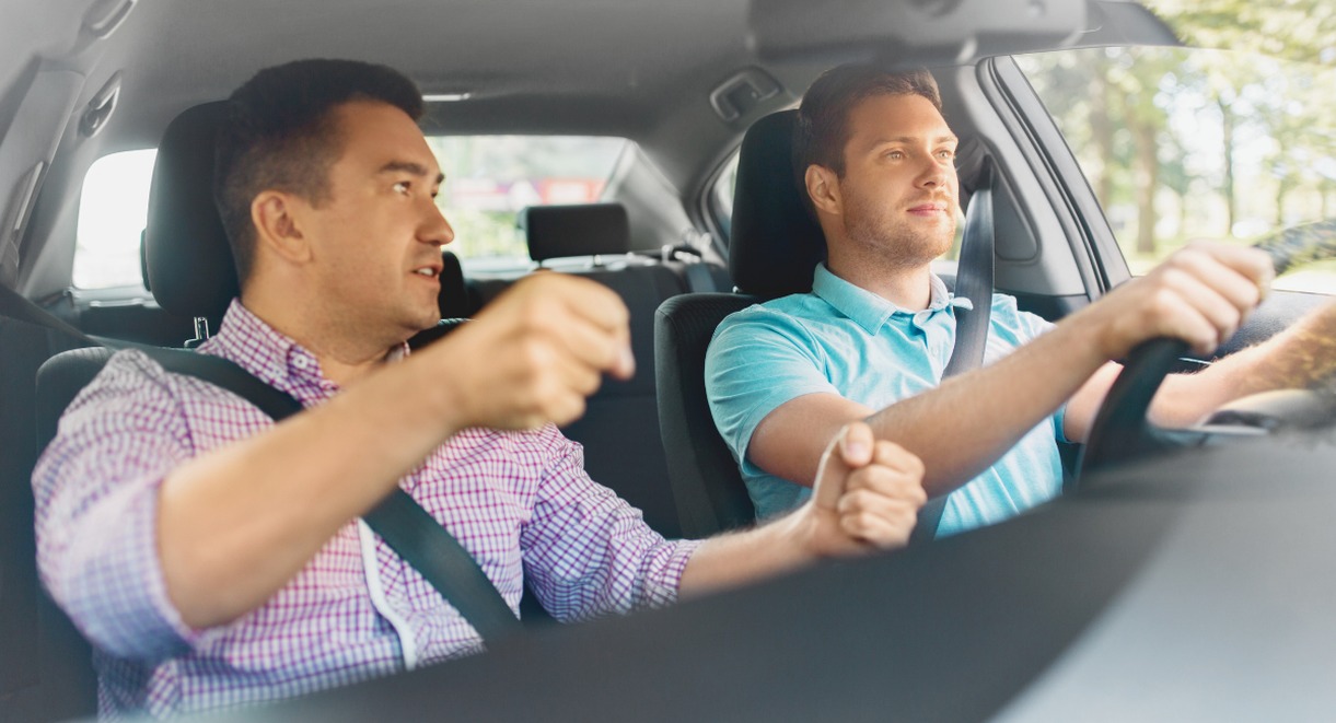 Accompagnateur assis à côté d'un jeune conducteur en pleine conduite