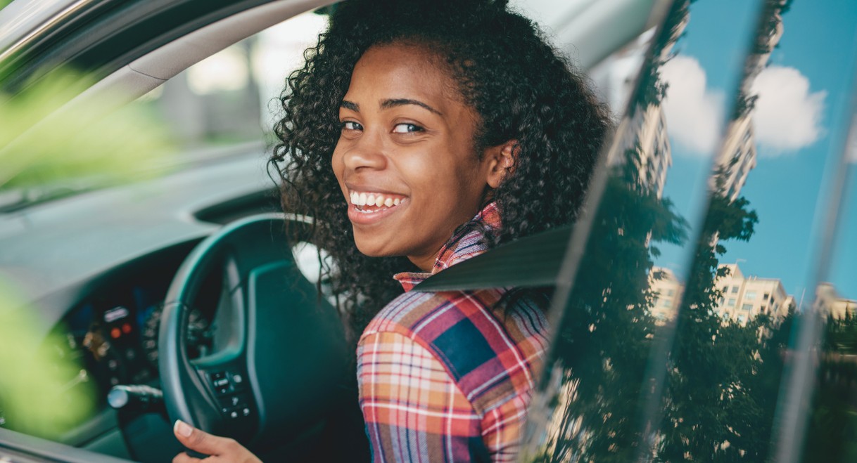 Conductrice souriante prenant une leçon de conduite au volant