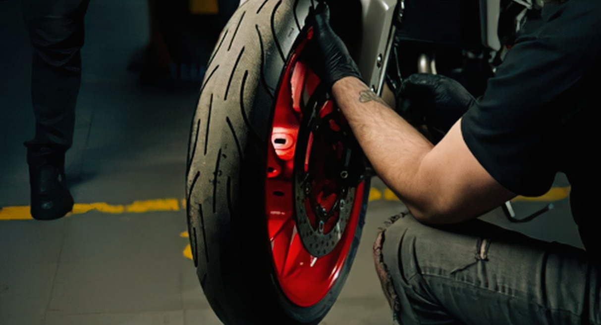 Mécanicien inspectant la roue avant d'une moto en garage