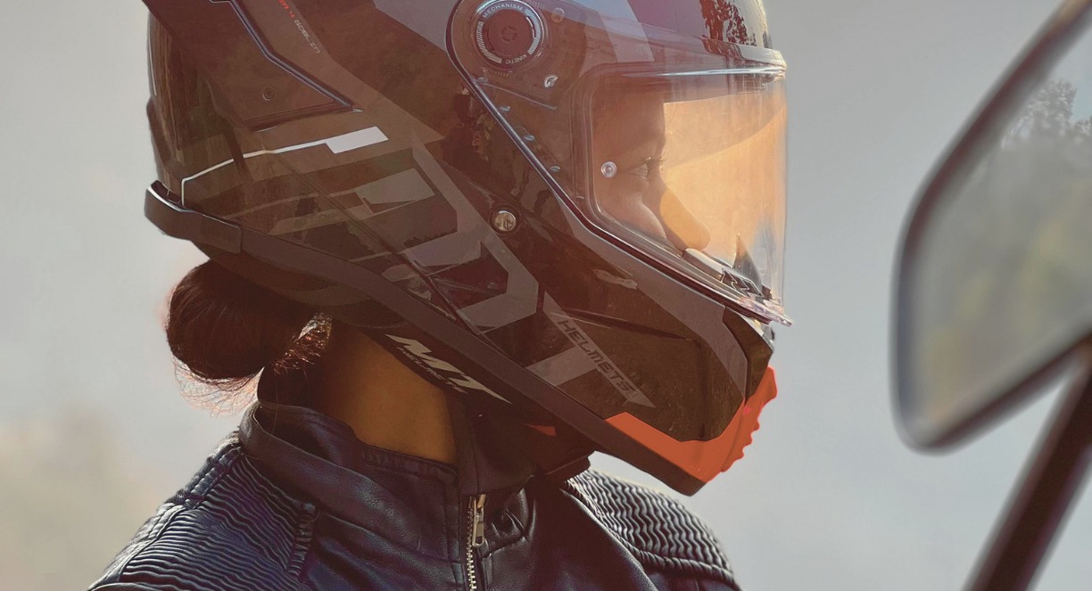 Motarde équipée d'un casque intégral au lever du soleil