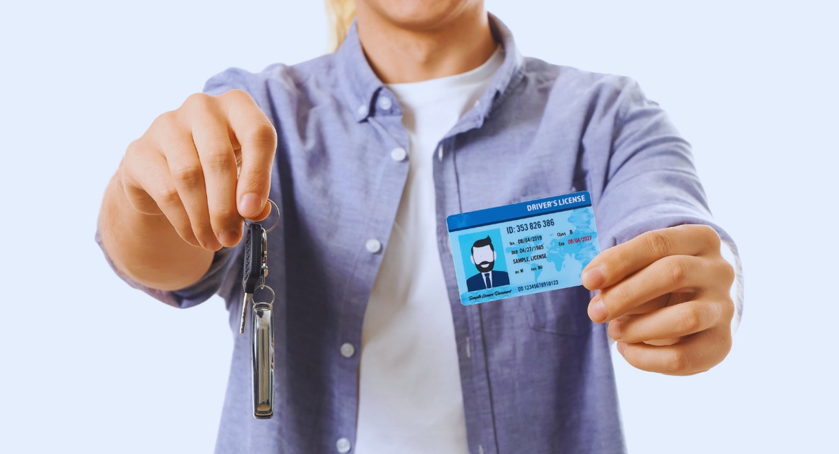 Jeune conducteur tenant son permis de conduire et sa clé de voiture