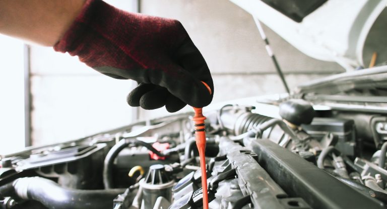 Controle du niveau d huile avec la jauge sous le capot ouvert d une voiture
