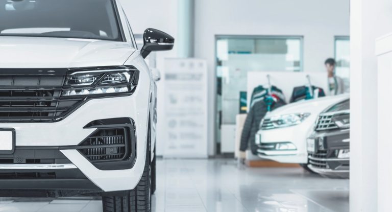 Plusieurs voitures neuves blanches exposees dans une concession automobile