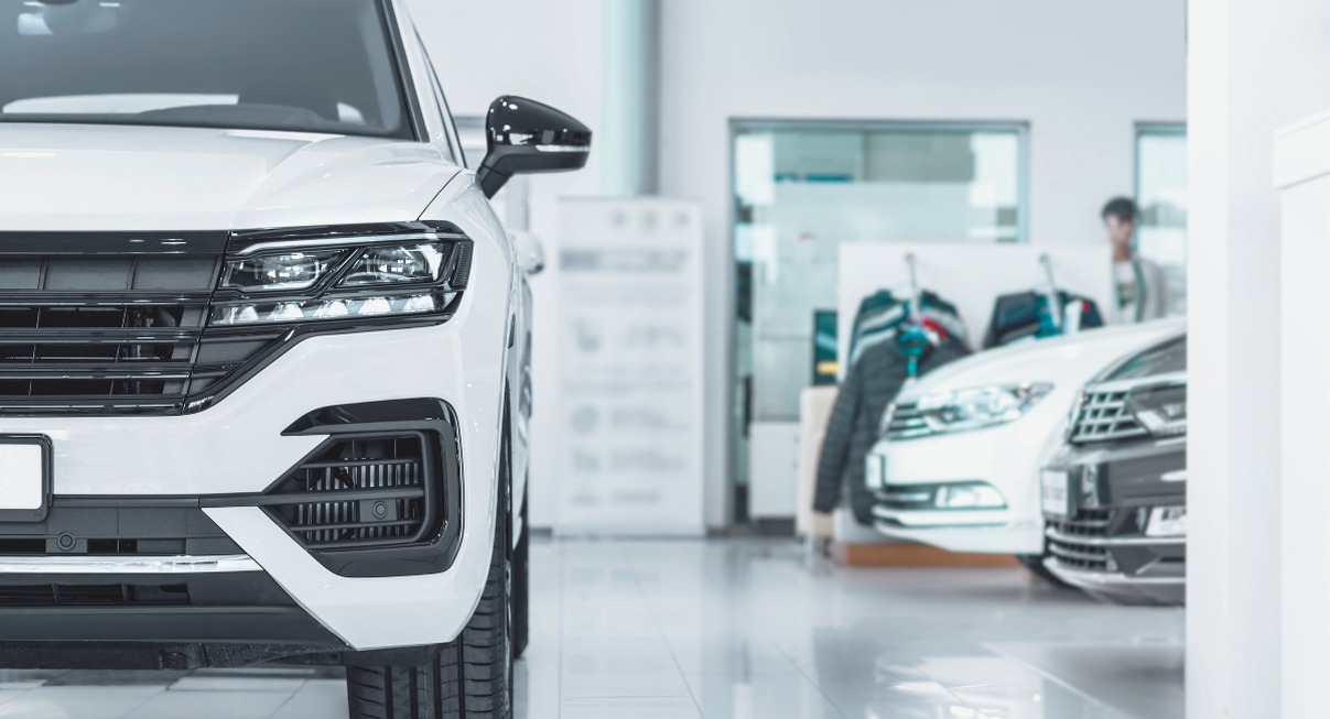 Plusieurs voitures neuves blanches exposees dans une concession automobile