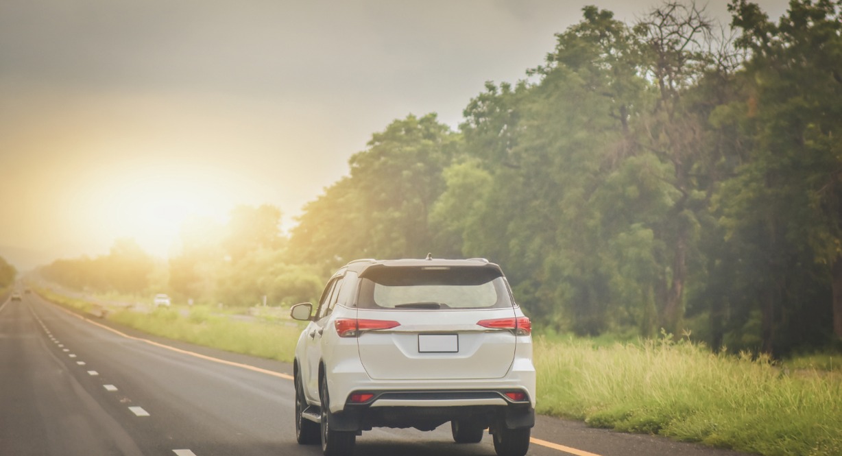 Voiture roulant sur une route de campagne au coucher du soleil
